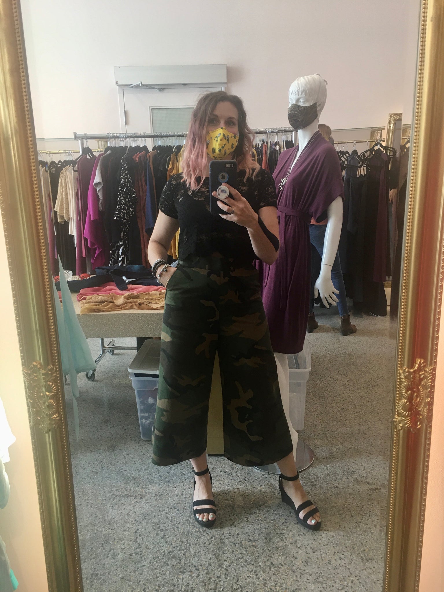 Model takes selfie in shop wearing black lace RG Crop top and camo print cropped wide leg Jill Pants. She is 5'5" tall