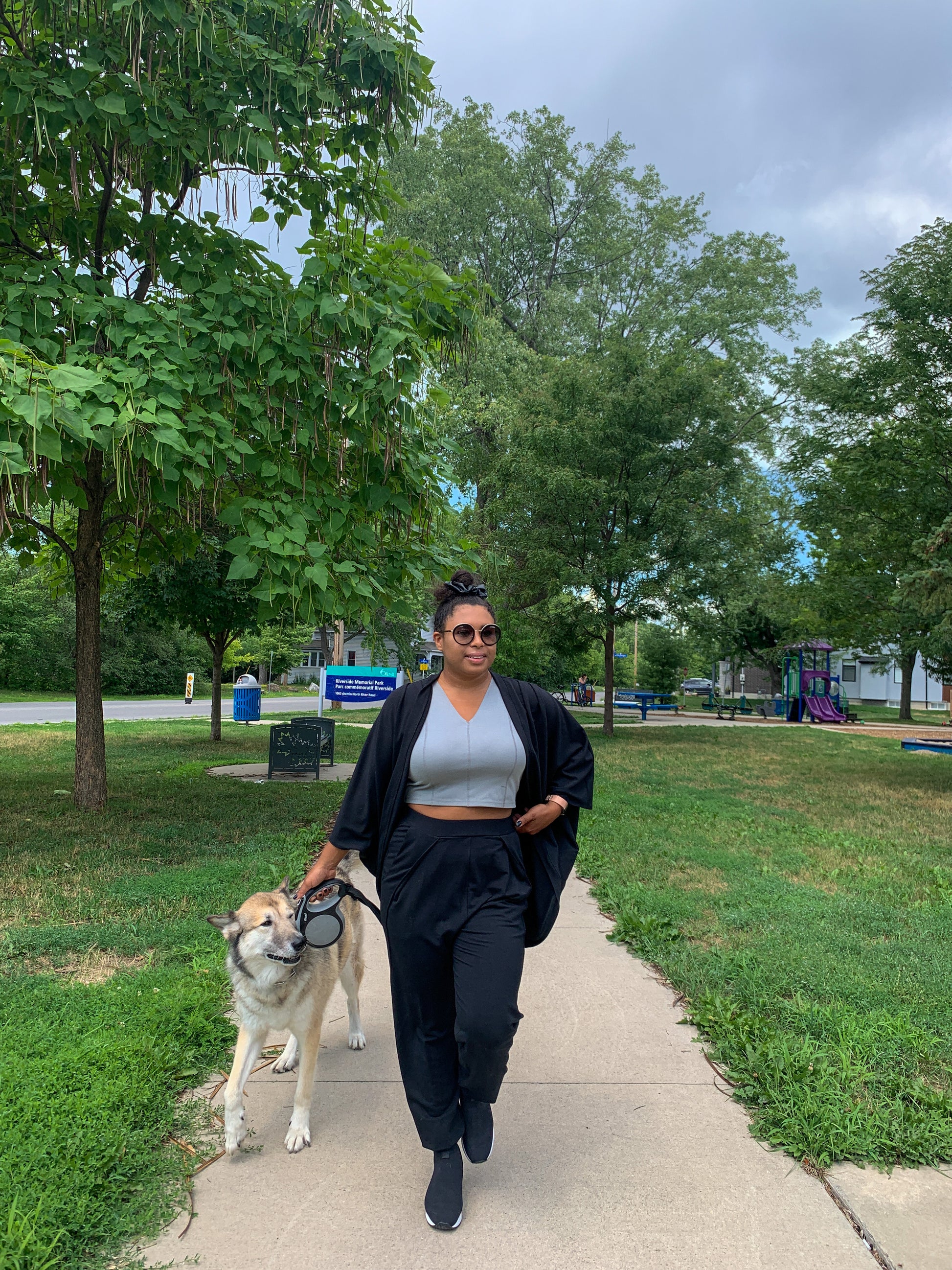 Model walks dog wearing high waisted Tucks pants in XL with crop top and black bamboo/cotton Pippa shrug. She is 5'3" tall