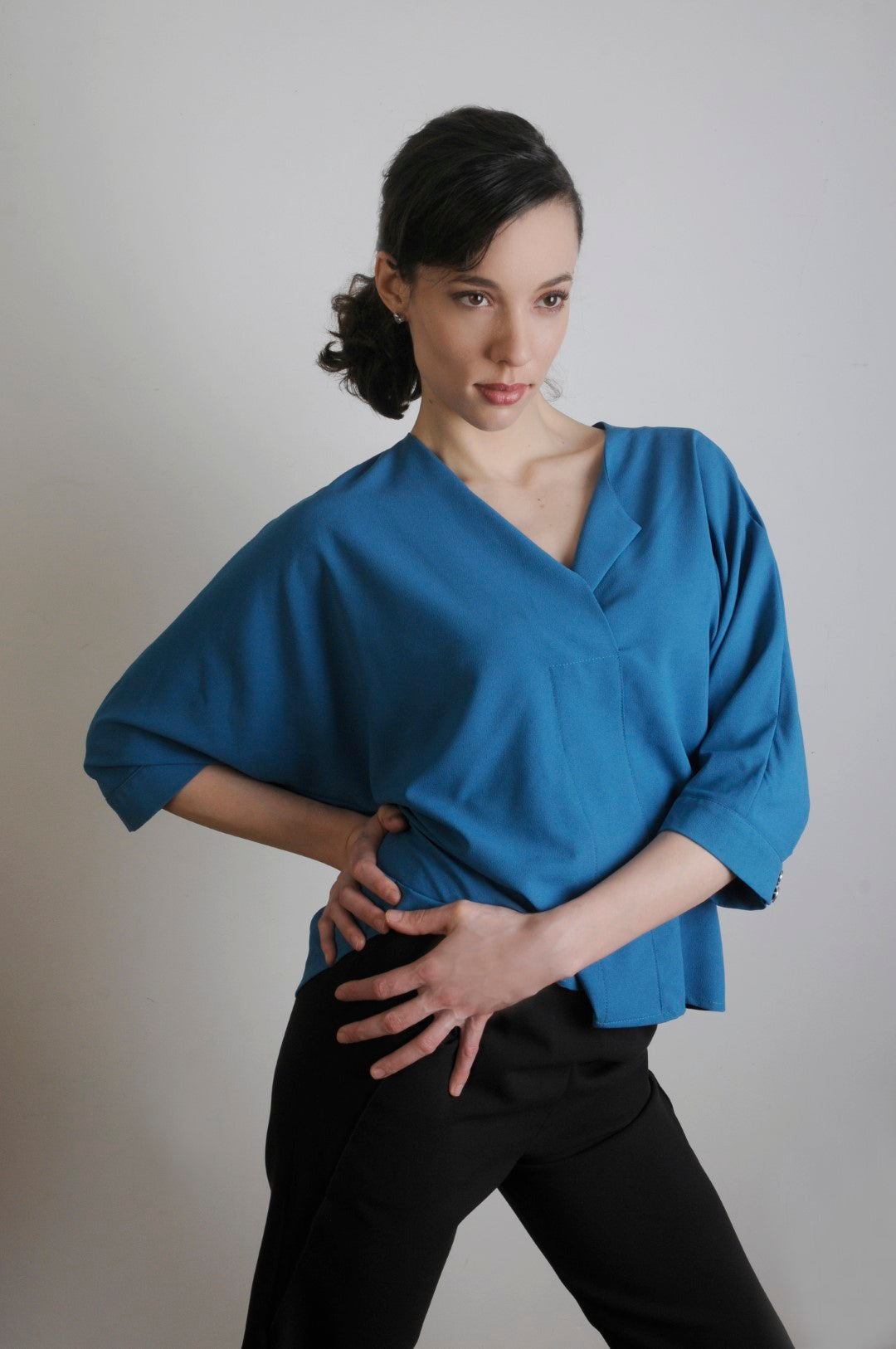 Model wears Bella blouse in teal  in an oversized XL for her small frame. She is 5'11' tall