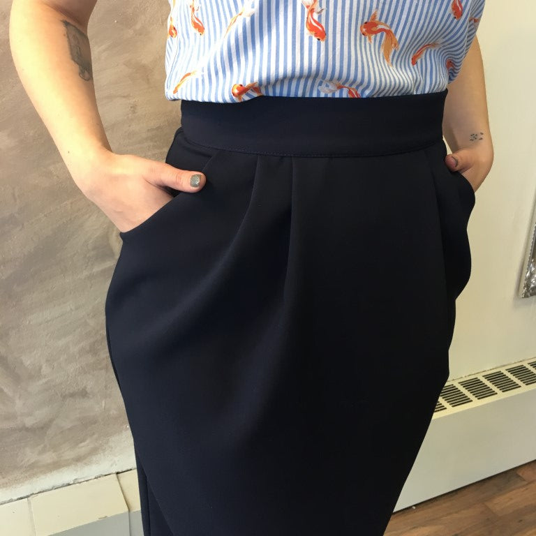 Model wears navy Vere skirt in L with M Think Tank. She is 5'8" tall. Detail shot of pleats and pockets
